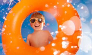 young boy in bright orange swim ring