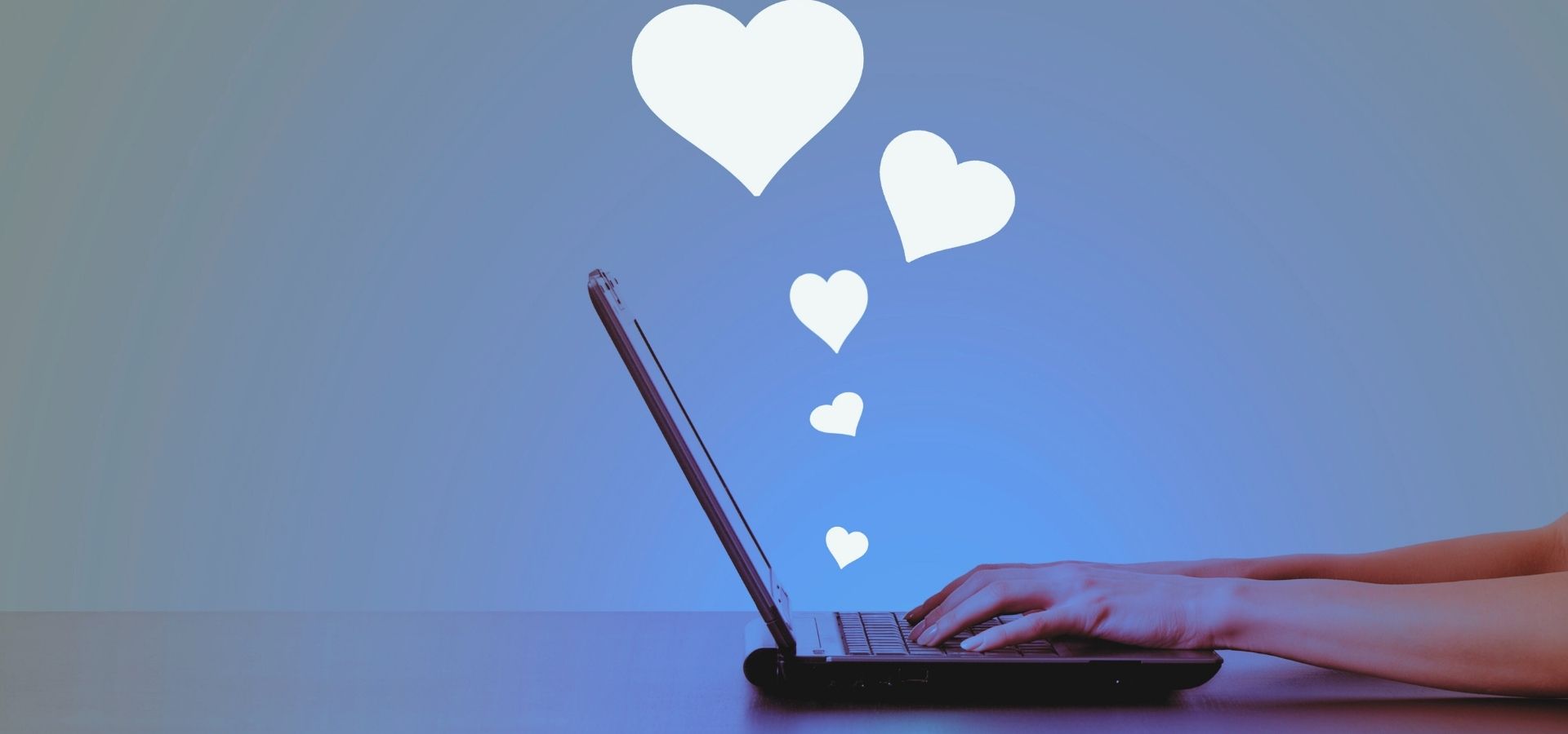 laptop with hearts floating above it